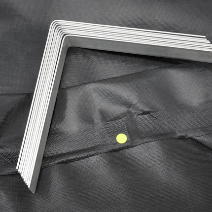 A stack of silver aluminum  L-brackets arranged in an L-shape on a black textured fabric background.