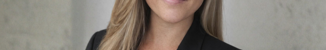 Woman wearing a black blazer against a neutral background
