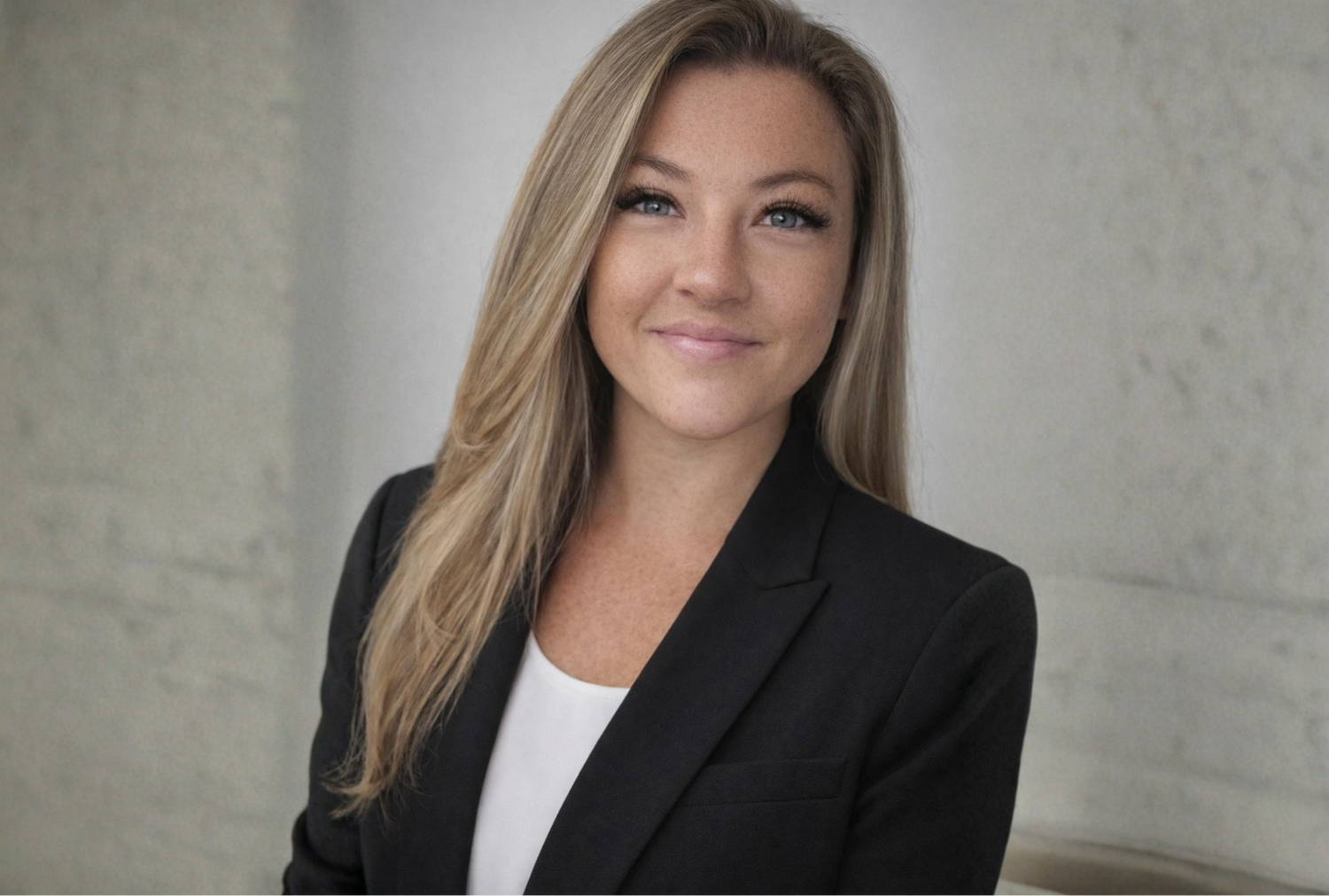Woman wearing a black blazer against a neutral background