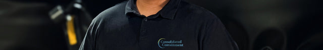 Person wearing a black shirt with a logo in front of a dark background