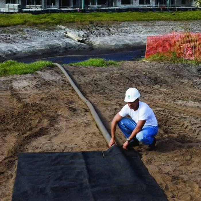 A man in a hard hat hooks up a dewatering bag