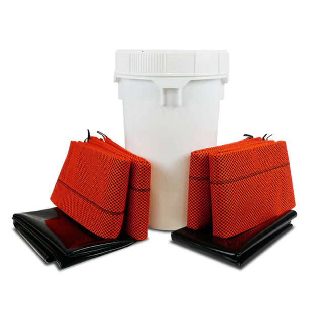 A small white drum with bright orange barriers and black mats
