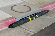 A Spill Bully Curb Inlet Filter resting against a curb in a street side drain