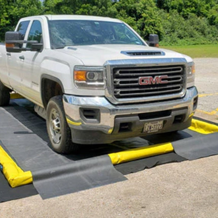 A berm pad with a ProFlex Foam Wall Berm and track guards with a white truck driving over berm