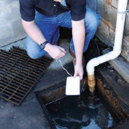 A man puts an Ultra-Archaea boom in a drain