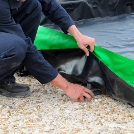 A man inserting stakes into an Ultra-Collapsible Berm