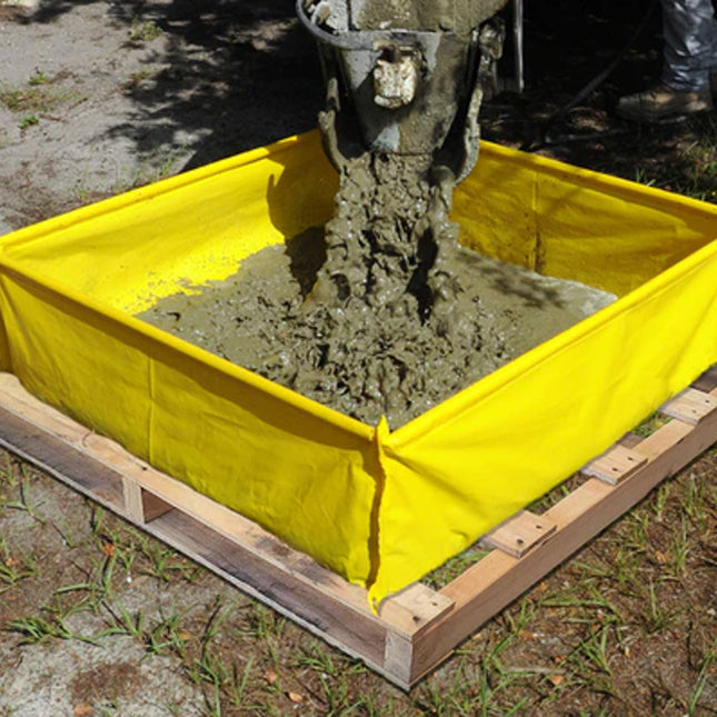 A yellow washout berm on top of a pallet with concrete mix being poured into it