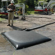 A man with a big mustache and a clipboard takes notes on how the Ultra-Dewatering bag is performing